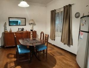 a kitchen with a table and chairs and a refrigerator at Wind & Way Hostel in Valparaíso