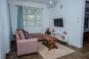 a living room with a couch and a table at Auregi Villas in Diani Beach
