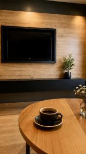 a cup of coffee sitting on a table in front of a tv at Sezgin Hotel in Uzungöl +47 photos