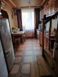 a kitchen with a refrigerator and a table at Котедж Криниченька in Yaremche