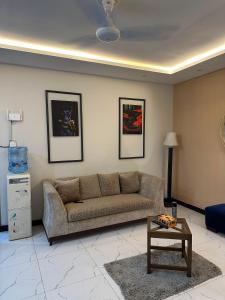 a living room with a couch and a table at The crimson round bed luxe suite in Rawalpindi