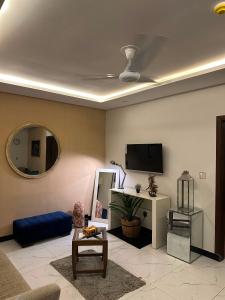 a living room with a blue couch and a tv at The crimson round bed luxe suite in Rawalpindi