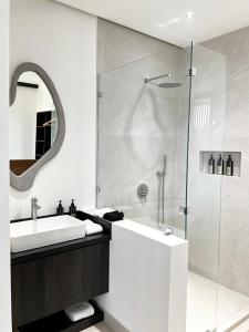 a bathroom with a sink and a shower at NOAM by the sea in Tamarindo +21 photos