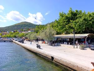 a group of people standing on a sidewalk next to a river at Murat Kaptan Apt in Gündoğdu
