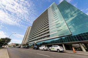 a large building with cars parked in front of it at Alugueasy - Hotel Vision in Brasília