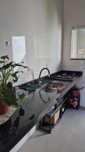a kitchen with a sink and a stove at Casa Real in Guarapari