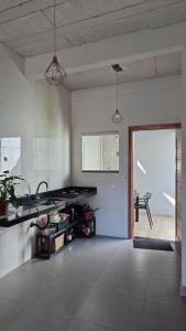 a large room with a kitchen with a table at Casa Real in Guarapari