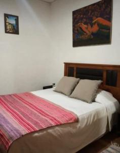 a bedroom with a bed with a red and white blanket at Wind & Way Hostel in Valparaíso