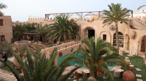 a resort with a swimming pool and palm trees at Tenasbook Jnen Rayhane in Midoun
