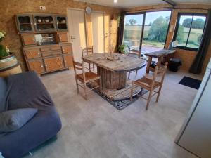 a living room with a wooden table and chairs at Refuge climatisé tout proche du Pal in Le Pin
