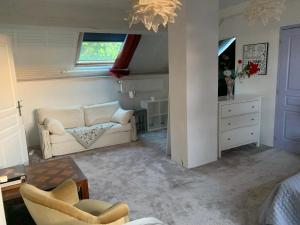 a living room with a couch and a table at Suite-piscine et jacuzzi sous les étoiles - petit déjeuner inclus ou non, et repas froid en option in Septème