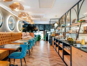 a dining room with tables and blue chairs at Hotel Suites Feria de Madrid in Madrid