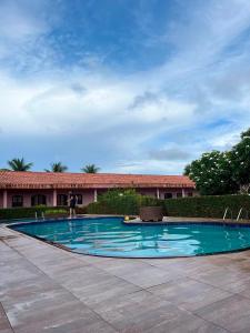 a large swimming pool in front of a building at Pousada Caranã in Salinópolis