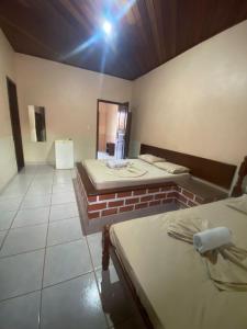a room with two beds and a mirror at Pousada Caranã in Salinópolis