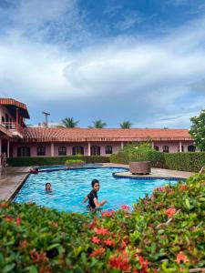 a young boy swimming in a swimming pool at Pousada Caranã in Salinópolis +3 photos