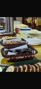 a table topped with different types of food on at Pousada Caranã in Salinópolis