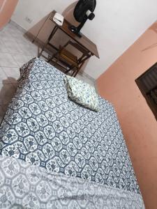 a bed with a pillow on top of it at Quarto Bem Localizado em Lugar Tranquilo in Barueri