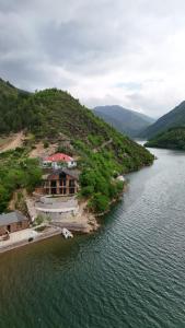 a house on a hill next to a river at Villa Sajmo in Koman