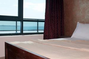 a bedroom with a bed and a large window at Maison Babacar TOURE in Dakar