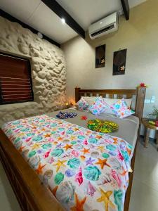 a bedroom with a large bed with a colorful comforter at Paradise Resort Taveuni in Waiyevo +82 photos