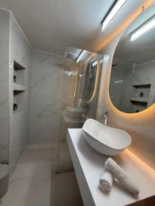 a white bathroom with a sink and a mirror at Meraki Luxury Retreat in Kos +40 photos