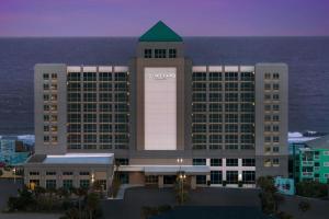 a rendering of a hotel with the ocean in the background at Courtyard by Marriott Carolina Beach Oceanfront in Carolina Beach