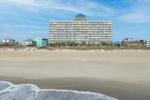 a large building on the beach with the sand at Courtyard by Marriott Carolina Beach Oceanfront in Carolina Beach