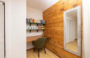 a room with a wooden wall with a mirror and a chair at Blue Mountains Cabin in Boquete