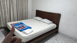 a bed in a room with a person reaching for a towel at Quarto Bem Localizado em Lugar Tranquilo in Barueri