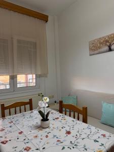 a dining room table with a flower vase on it at Dimi's Apartment Avdira in Ávdhira +8 photos