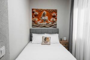 a bedroom with a bed with a painting on the wall at Defne House Urla in Urla