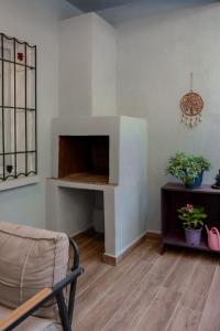 a room with a fireplace with a chair and plants at Defne House Urla in Urla