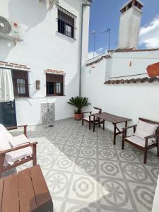 a patio with benches and tables on a building at Casa Monte Los Peñasquitos in Cazalla de la Sierra