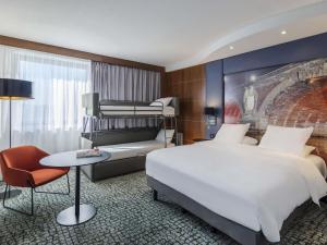 a hotel room with a bed and a couch at Hotel Mercure Toulouse Centre Compans in Toulouse