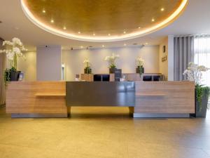 a lobby with a reception desk in a building at Mercure Hotel Stuttgart Airport Messe in Stuttgart