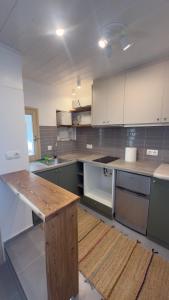 a kitchen with white cabinets and a wooden table at Amerissas studios 4 in Skiros