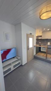 a living room with a flat screen tv and a kitchen at Amerissas studios 4 in Skiros +3 photos