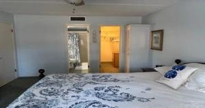 a bedroom with a large bed with a blue and white blanket at Serene Florida Oasis in Inverness
