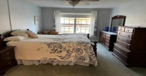 a bedroom with a bed and a dresser and a window at Serene Florida Oasis in Inverness