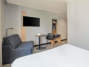 a hotel room with a bed and a couch and a table at ibis Saint Quentin Centre Basilique in Saint-Quentin