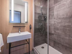 a bathroom with a sink and a shower at ibis Saint Quentin Centre Basilique in Saint-Quentin +57 photos