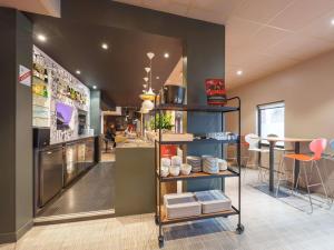 a restaurant with a counter and tables and chairs at ibis Saint Quentin Centre Basilique in Saint-Quentin