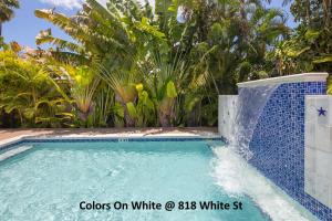 a swimming pool with a waterfall in a resort at Colors on White in Key West