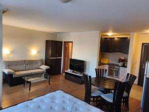 a living room with a couch and a table at Апартаменти-Студия в Комплекс Нестинарка in Tsarevo