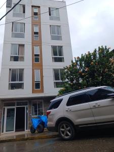 a van parked in front of a tall building at Haylli Café Oro Hotel in Santa Teresa