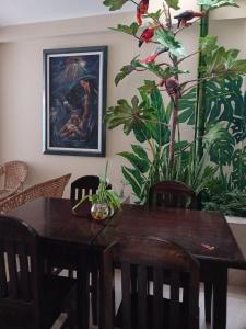 a dining room table with chairs and a painting on the wall at Haylli Café Oro Hotel in Santa Teresa