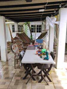 a patio with a table and chairs and hammocks at PlayaMariaChiquita in Colón