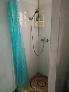 a shower with a blue shower curtain in a bathroom at PlayaMariaChiquita in Colón