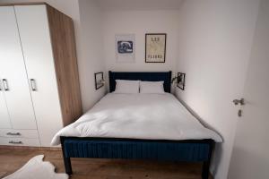 a bed with a blue frame in a bedroom at Modern Studio Apartment in Žepče