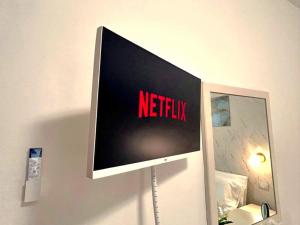 a television on a wall with the word netflix on it at Port Haven Suite Civitavecchia in Civitavecchia